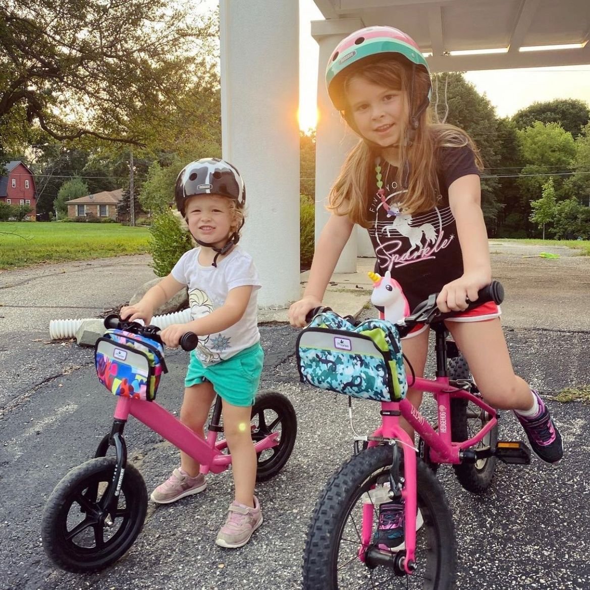 Two young girls on their pink bicycles decked out in Po Campo gear.