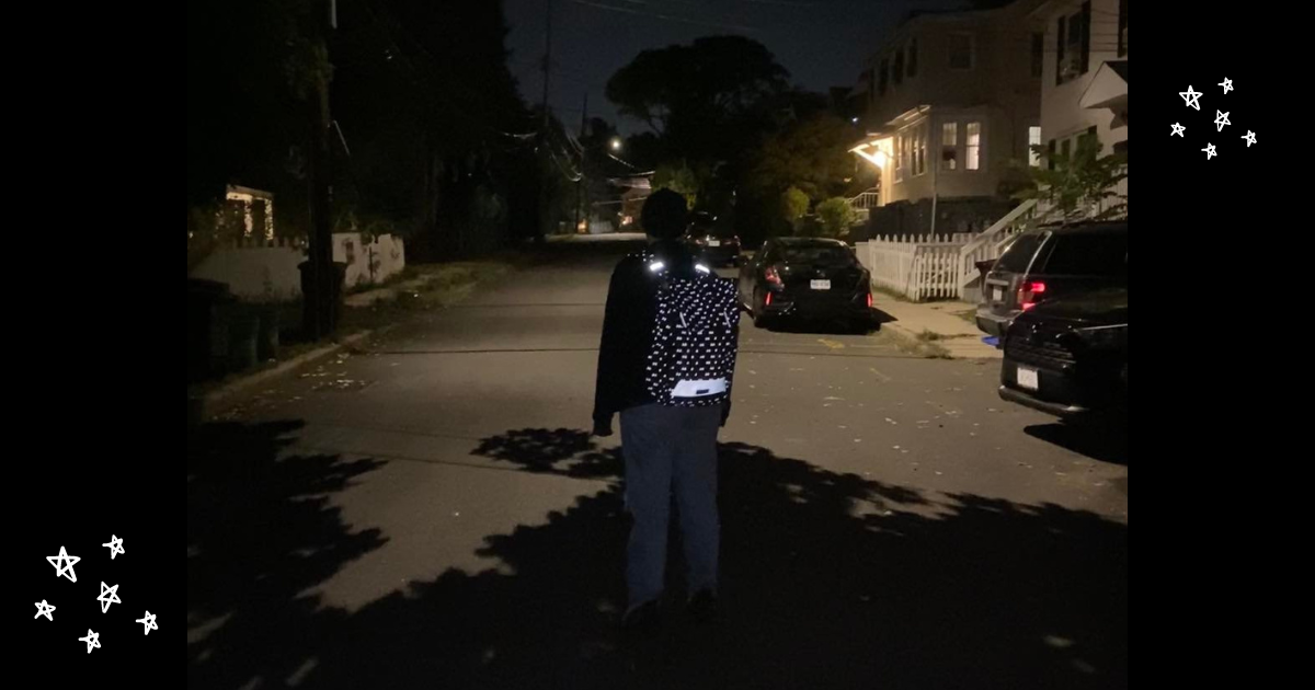 A person wearing a Po Campo reflective backpack on a dark street.