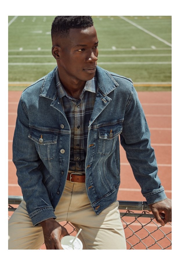 Man wearing jean jacket at a football game 